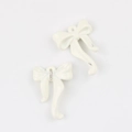 Detalle macro de colgantes de lazo en esmalte crema con cristales para joyería DIY - Blanco Crema