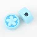 Macro detail of sky blue flower-embossed round beads for DIY jewelry crafting and design - Blue