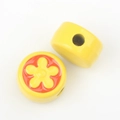 Detailed view of yellow ceramic beads with red flower pattern for DIY jewelry crafts - Yellow