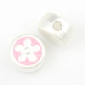 Close-up of silver-tone round beads with pink enamel flower for DIY jewelry making - Silver White