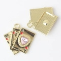 Detail of light gold alloy poker pendant with pink heart crystal and back texture - Gold / Pink
