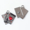Macro view of poker card charms with red heart gem and textured metal reverse side - Gunmetal Red Zirconia