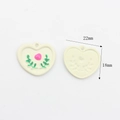 Makro-Detail von Herz-Blumen-Anhänger mit cremefarbener Front und strukturierter Rückseite - Weißes Herz