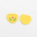 Detailansicht herzförmiger Blumenanhänger mit rosa Relief auf gelbem Hintergrund - Gelb