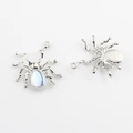 Detailansicht der Spinnenanhänger mit blauem Kristall und strukturierter Rückseite - Silber