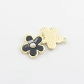 Detail eines schwarzen Blumenanhängers mit Perle und strukturierter goldener Rückseite - Schwarz Goldbeschichtet