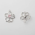 Detailansicht der hohlen Blumenanhänger mit rosa Strasssteinen und silbernem Finish - Silberrand Rosa
