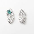 Macro detail of alloy flower pendant with green teardrop gem and textured back - Silver / Green