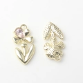 Detail of flower-shaped alloy pendants with pink teardrop stones and textured golden back - Gold / Pink