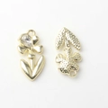 Macro detail of gold flower charm showing teardrop zircon and textured back side - Gold / White Zirconia