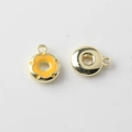 Macro detail of alloy donut charm with yellow enamel finish and golden metal backing - Yellow with Gold Back
