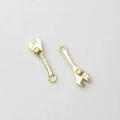 Close-up of golden mini wrench pendants with detailed adjustable dials and hanging holes - Gold
