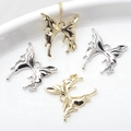 Macro view of liquid metal butterfly alloy pendants in gold and silver mirror finish - Random Mixed
