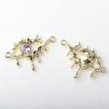 Macro detail of gold molten eye pendant with purple gem and dual connector rings - Eye Shape (WSX-1642) / Gold Purple Rhinestone