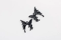 Macro view of fluid butterfly charms showing mirror polished front and matte textured back - Black