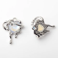 Macro view of heart pendants with fluid silver metal and iridescent opal-like inlay - Silver