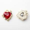 Voor- en achterkant van een gouden hartvormige hanger met rode steen voor het maken van sieraden - Goud / Rood