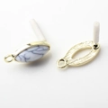 Macro detail of oval gold-plated earring connectors with white marble stone inlays - White (Textured)