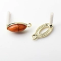 Macro view of golden olive-shaped earring base with orange textured gemstone inlay - Orange (Textured)