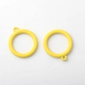 Macro shot of two bright yellow matte alloy hollow round charms for DIY jewelry making - Yellow