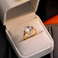 Gouden emaille klavertje ring met paarse bloemblaadjes en witte parel in een sieradendoos - Open ring / Parelpimpelpaars & Parelmoer Wit