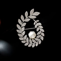 Elegante broche de espiga con perla blanca y cristales brillantes sobre fondo negro - Plateado