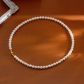 Collier de perles élégant avec fermoir magnétique doré sur une surface en cuir marron - Style Standard Perle Taille 6