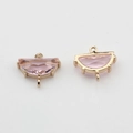 Close-up of pink crystal semi-circle connectors in gold plated settings for DIY jewelry - Pink