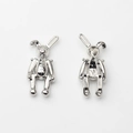 Vue détaillée des pendentifs lapin montrant textures mécaniques et dos creux - Aiguille en argent