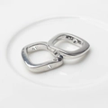 Close-up of polished silver alloy square charms with side holes for DIY jewelry making - Silver