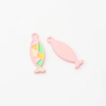 Macro-opname van kleurrijke emaille visbedeltjes met geometrische patronen voor DIY sieraden - Roze Vis
