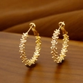 Créoles dorées avec finition texturée unique posées sur une surface en bois vintage - Style Or 14K 30#