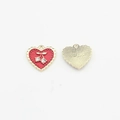 Detailed view of red heart pendant with cherry crystal inlay and gold textured back - Red
