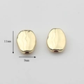 Macro shot of 11x9mm golden hammered texture oval metal beads for DIY jewelry making - Ellipse