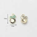 Detail view of 16x10mm vegetable charm with golden alloy base and green enamel leaves - Carrot