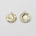 Macro detail of vintage gold coin pendant with portrait relief and small clear crystals - Gold
