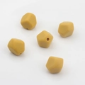 Dettaglio di 5 perle in silicone alimentare giallo senape sfaccettate per creazioni DIY - Giallo