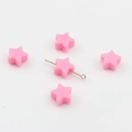 Dettaglio di perline in silicone rosa a forma di stella con fori centrali per fai da te - Rosa