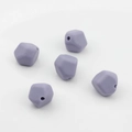 Vista macro de cinco cuentas de silicona lila facetadas para manualidades y joyería DIY - Gris