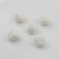Primer plano de cinco cuentas geométricas de silicona blanca con agujeros para joyería DIY - Blanco