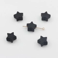 Gros plan sur des perles étoiles en silicone noir de 14mm avec perçage pour bijoux - Noir