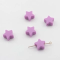 Gros plan de perles étoiles en silicone violettes 14mm avec trous pour bijoux DIY - Violet