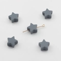 Vue macro de perles en silicone en forme d'étoile grise montrant des trous horizontaux - Gris