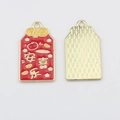 Macro view of red enamel peace and joy pendant with gold metal texture on the back - Peace and Joy