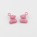 Detailopname van twee roze emaille beertjes hangers met lussen voor DIY-sieraden maken - Roze