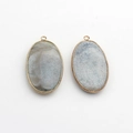 Macro detail of oval dragon vein agate pendants with gold metal edges and intricate patterns - Blue