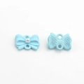 Dettaglio di ciondolo a fiocco azzurro con perla bianca e texture posteriore zigrinata - Blu