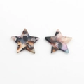 Macro view of star-shaped amber resin pendants with colorful marbled tortoiseshell texture - Colorful