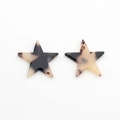 Macro detail of star-shaped acetate resin pendants with black and white marble textures - Apricot