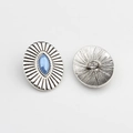 Close-up of vintage oval silver alloy button with sunburst texture and blue stone - Lake Blue